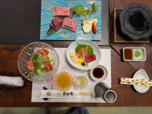 Japanese Kaiseki - A multicourse feast including plum wine, salad, sashimi, grilled wagyu beef, soup, rice, pickles, 